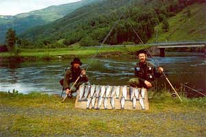 Ett par nöjda fiskare poserar framför sin dagsfångst.